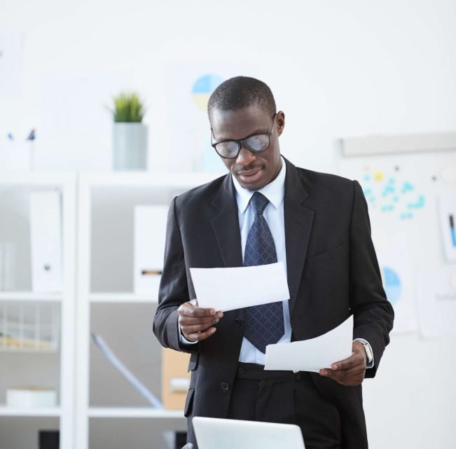 professional-man-reviews-documents-at-office-desk-2026-03-18-15-48-29-utc(1)